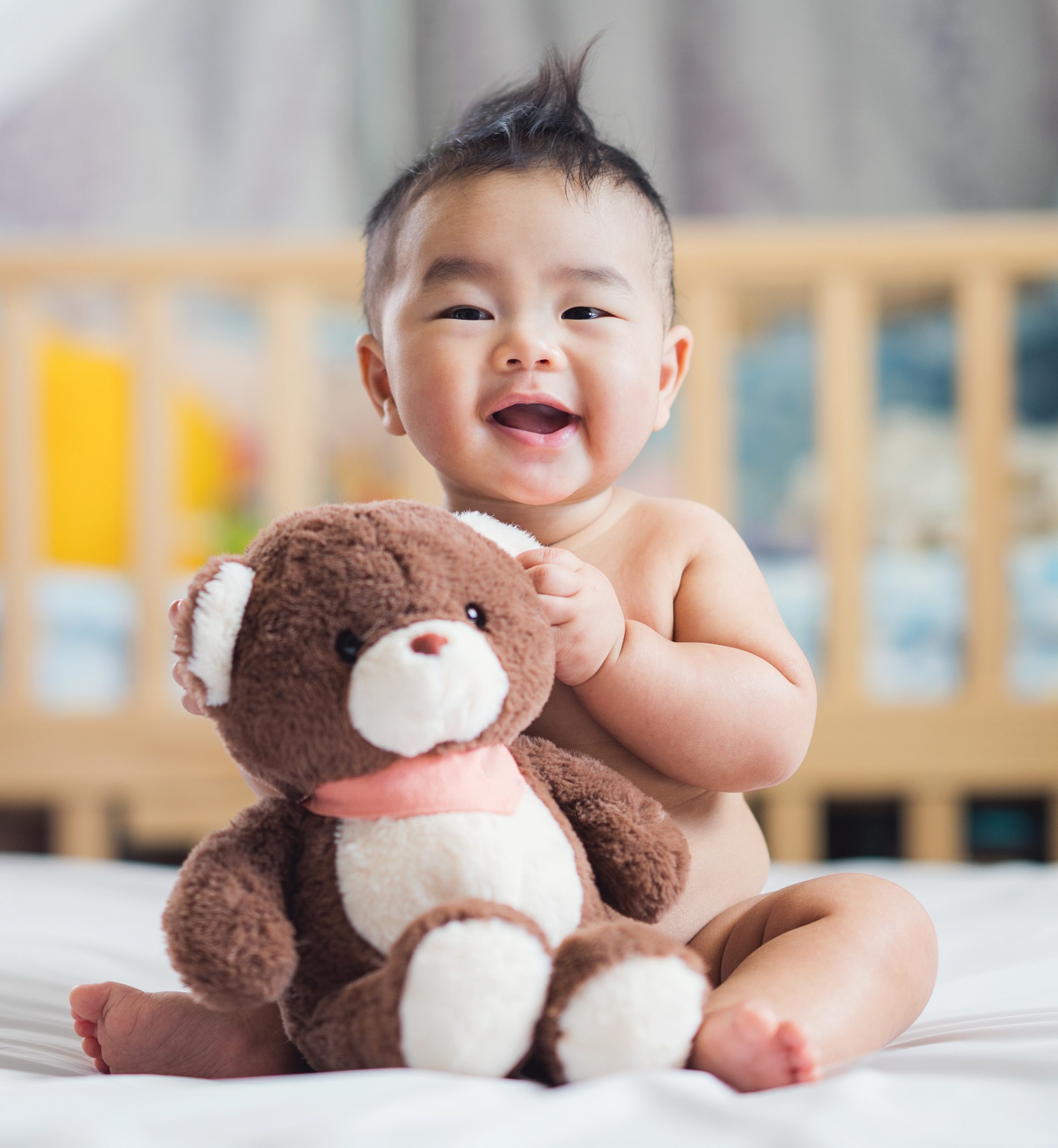 Asian,Baby,Sit,With,Teddy,Bear,On,Ther,Bed,In Asian baby